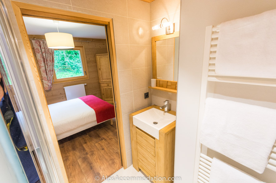 Appartement CH8 Morillon - La chambre double au niveau inférieur offre le luxe d'une salle de bain attenante avec douche