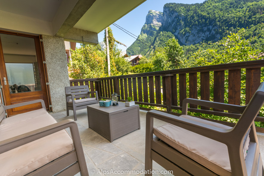 Chalet Falconnières Samoëns - Un coin salon couvert est parfait pour prendre un café le matin alors que le soleil se lève sur la spectaculaire montagne du Criou