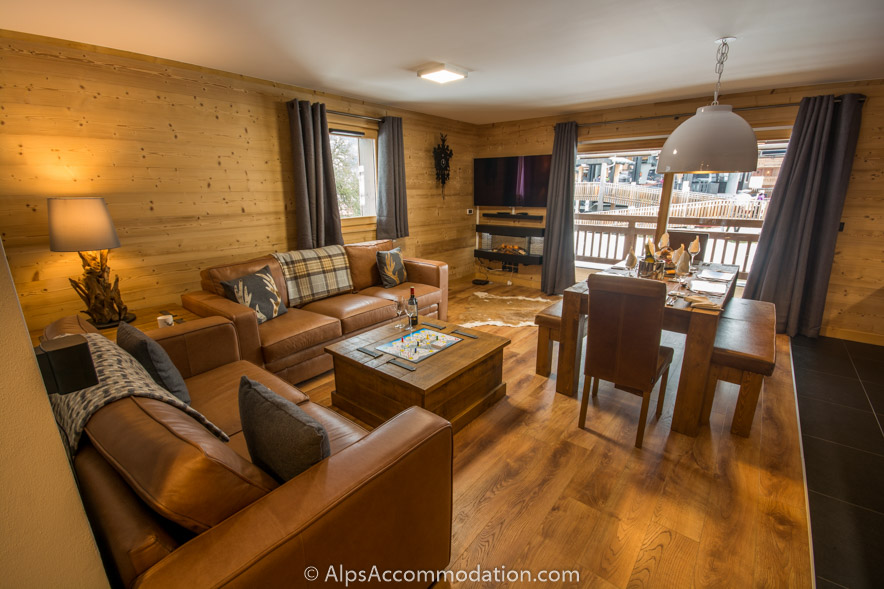 Appartement CH7 Morillon - Le salon confortable dispose de canapés en cuir et d'un feu de bois électrique