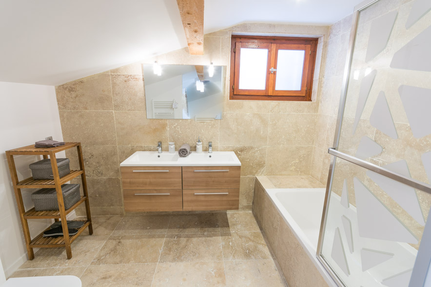 Chalet Falconnières Samoëns - Salle de bain attenante comprenant une grande baignoire avec douche et carrelage en pierre de qualité